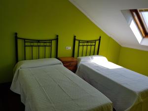 コンバーロにあるPiso Maceira Combarroの緑の壁のドミトリールーム ベッド2台