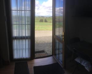 uma porta aberta com vista para um campo exterior em Baurleigh studio apartment P72F340 em Lissaphooca Cross Roads