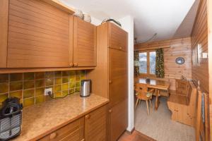 uma cozinha com armários de madeira e uma mesa num quarto em Alpenchalet Trutmundi undri em Eischoll