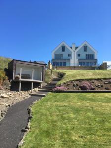 a house on top of a hill with a walkway at At The Beach Rooms in Portstewart