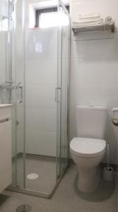 a bathroom with a toilet and a glass shower at Beira Rio do Gerês in Geres