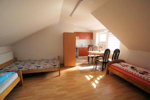 a room with two beds and a table with chairs at Agroturystka Na Polanie in Święta Katarzyna