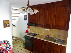 a kitchen with wooden cabinets and a sink and a stove at Casa Tainin in Valloria