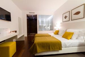 a bedroom with a large bed with yellow pillows at Hotel Vila D'Óbidos in Óbidos