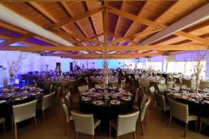 un salón de banquetes lleno de mesas y sillas en Hotel Vila D'Óbidos en Óbidos