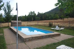 a swimming pool in a yard with a bench at Fuente de la Yedra in Arroyo Frio