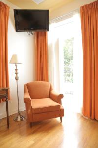 a living room with a chair and a flat screen tv at Hotel Casa Gonzalez in Mexico City