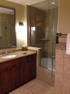 a bathroom with a sink and a shower with a glass door at Gateway Canyons Resort, a Noble House Resort in Gateway