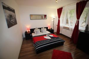 プラハにあるSmart City Prague Apartmentのベッドルーム1室(ベッド1台付)、赤いカーテン付きの窓が備わります。
