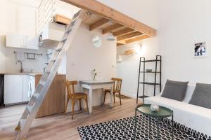 una sala de estar con una escalera que conduce a un loft en L'Escale, en Montpellier