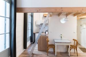 Una escalera que conduce a una cocina con mesa y sillas en L'Escale, en Montpellier 1 foto más