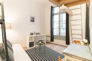 Una sala de estar con una mesa y una ventana. en L'Escale, en Montpellier