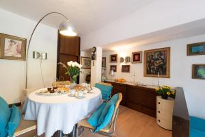 uma sala de jantar com uma mesa branca e cadeiras azuis em Relais Buonviaggio em La Spezia