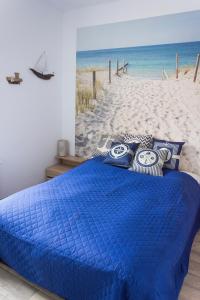 ウストカにあるPocztówkaのビーチの前に青いベッドが備わるベッドルーム1室