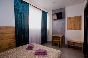 - une chambre avec un lit, une fenêtre et une table dans l'établissement OK Hotel, à Rivne