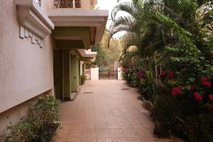 a walkway between two buildings with flowers and plants at Asian Golden Sands - S7 & S8 in Benaulim