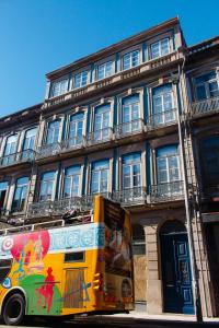 een gele bus geparkeerd voor een gebouw bij DL 205 in Porto