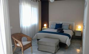アルムニェーカルにあるLovely House with views in Marina del Esteのベッドルーム(大型ベッド1台、椅子付)