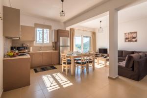 a kitchen and living room with a table and chairs at Abeli Villas in Nydri