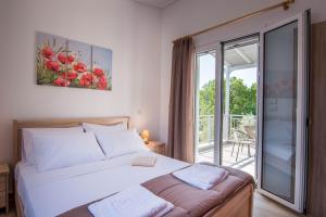 een slaapkamer met een groot bed en een balkon bij Abeli Villas in Nydri +32 foto's