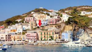 a cluster of houses on a hill with boats in the water at L'Isolana Case Vacanza Palma 1 in Ponza