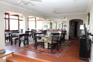 uma sala de jantar com mesas e cadeiras num restaurante em Kingston Place Guesthouse em Durban