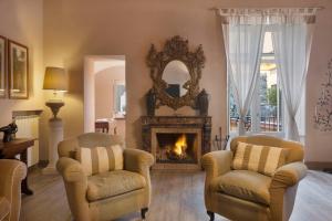 a living room with two chairs and a fireplace at "Maison de charme in Tasso square" in Sorrento