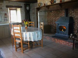 une salle à manger avec une table et une cheminée dans l'établissement Gîte au cœur du Lot, la maison de Pauline, à Lentillac du Causse