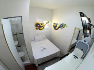 a small bathroom with a bed and a mirror at Balcony Hostel Hotel in São Paulo