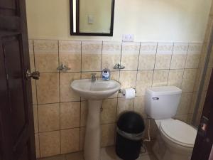 a bathroom with a sink and a toilet at Casa Lula León Hostal in León