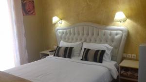 a bedroom with a white bed with two pillows at Mideia in Livadeia