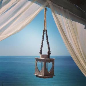 a chandelier hanging from a tent over the ocean at Villa Olga studios in Nea Skioni