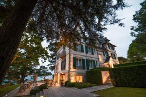 duży biały dom z zielonymi okiennicami w obiekcie Villa Tri Men w mieście Combrit