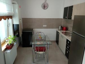 una pequeña cocina con mesa de cristal y silla en Apartament Ramona en Braşov