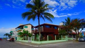 ein Haus mit einer Palme vor einer Straße in der Unterkunft Bangalô com vista para o mar. in Governador Celso Ramos