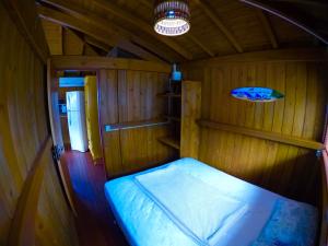 una piccola camera con un letto in una cabina di Bangalô com vista para o mar. a Governador Celso Ramos Altre 16 foto