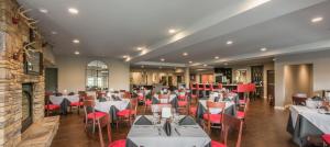 a dining room with white tables and red chairs at Valhalla Resort Hotel in Helen