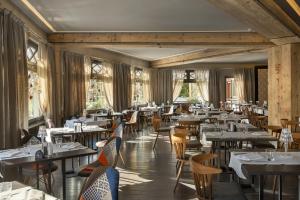 un comedor con mesas, sillas y ventanas en Hotel Europa en Breuil-Cervinia