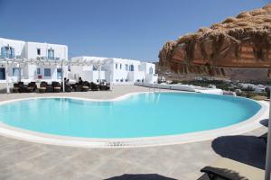 a large swimming pool on a patio with white buildings at Castellano Village in Analipsi