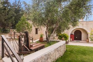 a house with a stone wall and a tree at Villa Aloni in Fílippos