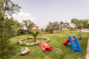 a group of childrens playground equipment in the grass at Villa Aloni in Fílippos