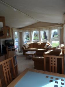 a living room with couches and a tv at Peace and quiet in countryside location near Perranporth in Perranzabuloe