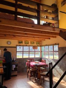 een persoon in een keuken met een tafel bij La Ribera - Sepúlveda 191 in El Chalten