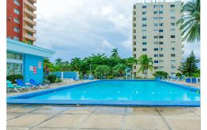 a large swimming pool in front of two tall buildings at Coconut Shell At Turtle Towers in Ocho Rios