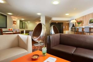 ein Wohnzimmer mit 2 Sofas und einem Tisch in der Unterkunft Hôtel Roissy in Lourdes