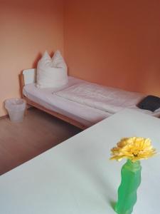 a room with two beds and a vase with a flower on a table at Gästezimmer Fuchs in Neuhausen auf den Fildern +14 photos