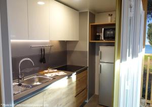 a kitchen with a sink and a refrigerator at Camping Home Adriamar in Novigrad Istria