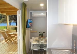 cocina y comedor con mesa y balcón en Camping Home Adriamar, en Novigrad Istria