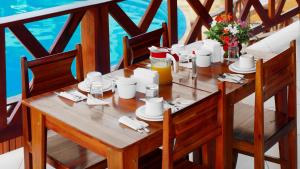a wooden table with a meal on a balcony at Jeri Hotel Group in Jericoacoara