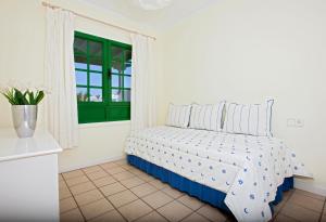 um quarto com uma cama e uma janela em Ana Iris Playa Las Cucharas em Costa Teguise